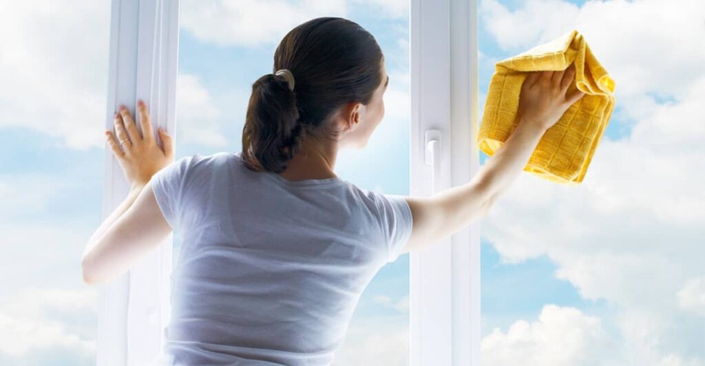 Frau will streifenfrei Fenster putzen
